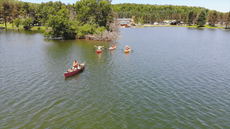 A group paddling canoes on Rainbow Lake