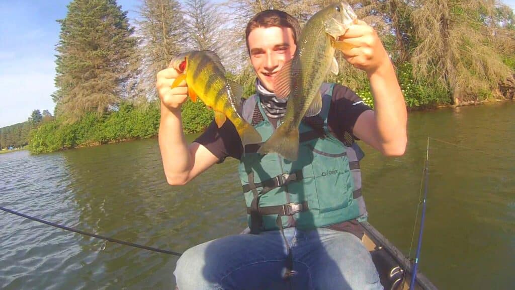 A man holding up two fish at a campground in Western New York.