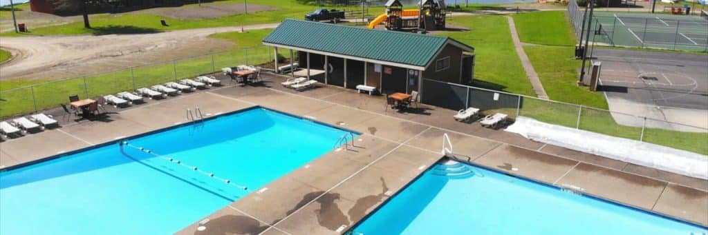 Aerial view of the two outdoor pools, playground and sport courts